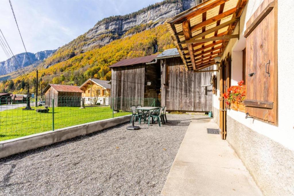 patio con mesa y vistas a la montaña en Le Gîte des Cascades en Sixt