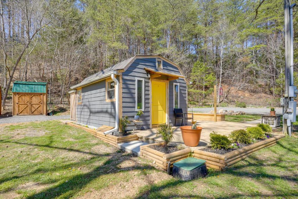 een kleine schuur met een gele deur in een tuin bij Blue Dream Cabin in Rising Fawn with Fire Pit! in Rising Fawn