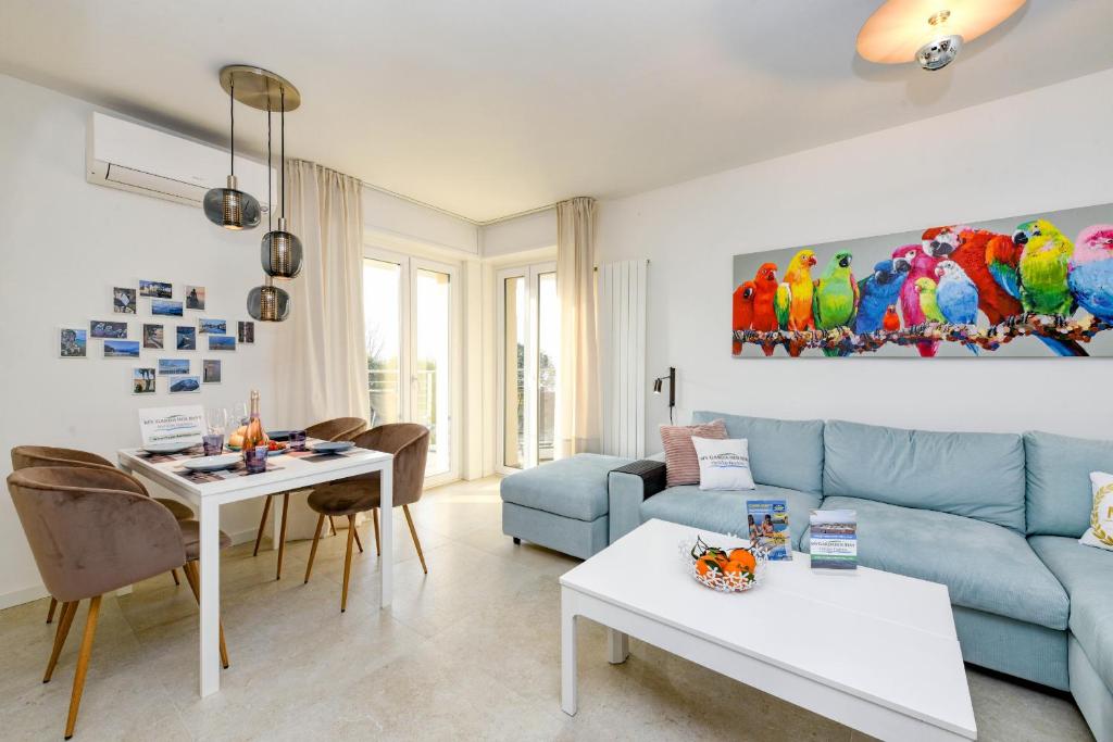 uma sala de estar com um sofá azul e uma mesa em MGH Family Stay - Costa DOro Superior Apartment em Sirmione