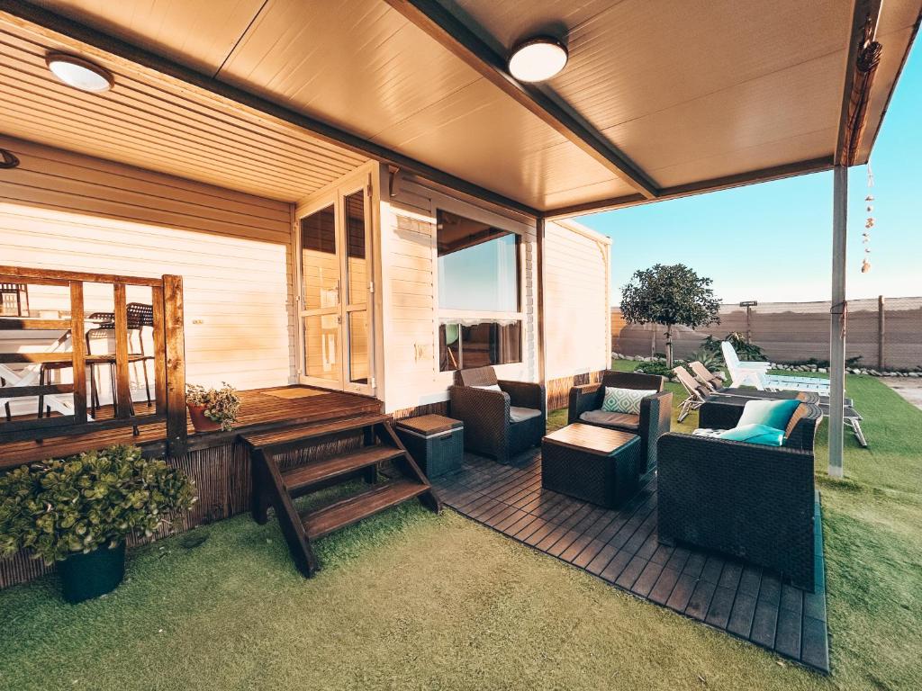 a screened in porch with couches and a bench at Palmaradise in El Palmar