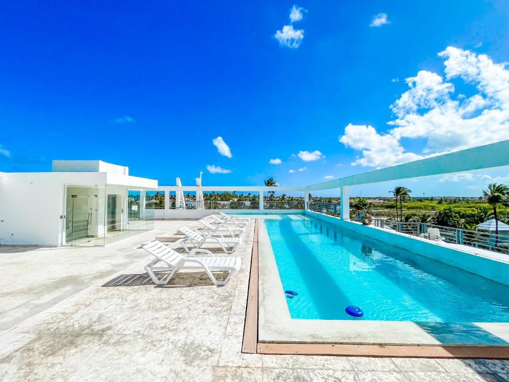 una piscina en la azotea de un edificio en ROOFTOP POOL Ducassi Tropicana STUDIO SUITES Deluxe HOTEL Beach Club & SPA, en Punta Cana