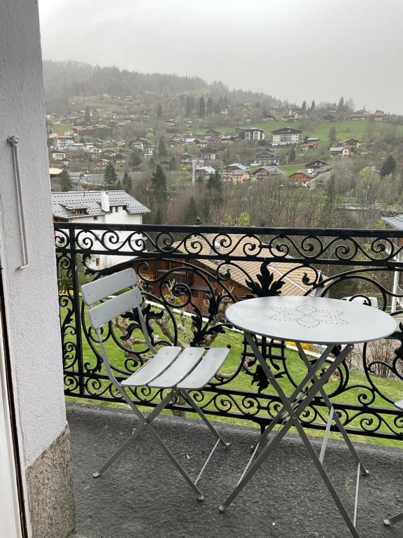 a balcony with two tables and a view of a city at Chambre centre Saint-Gervais Mont-Blanc in Saint-Gervais-les-Bains