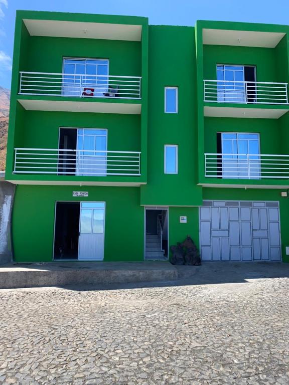 a green apartment building with two balconies at Casa Tchitchi in São Filipe