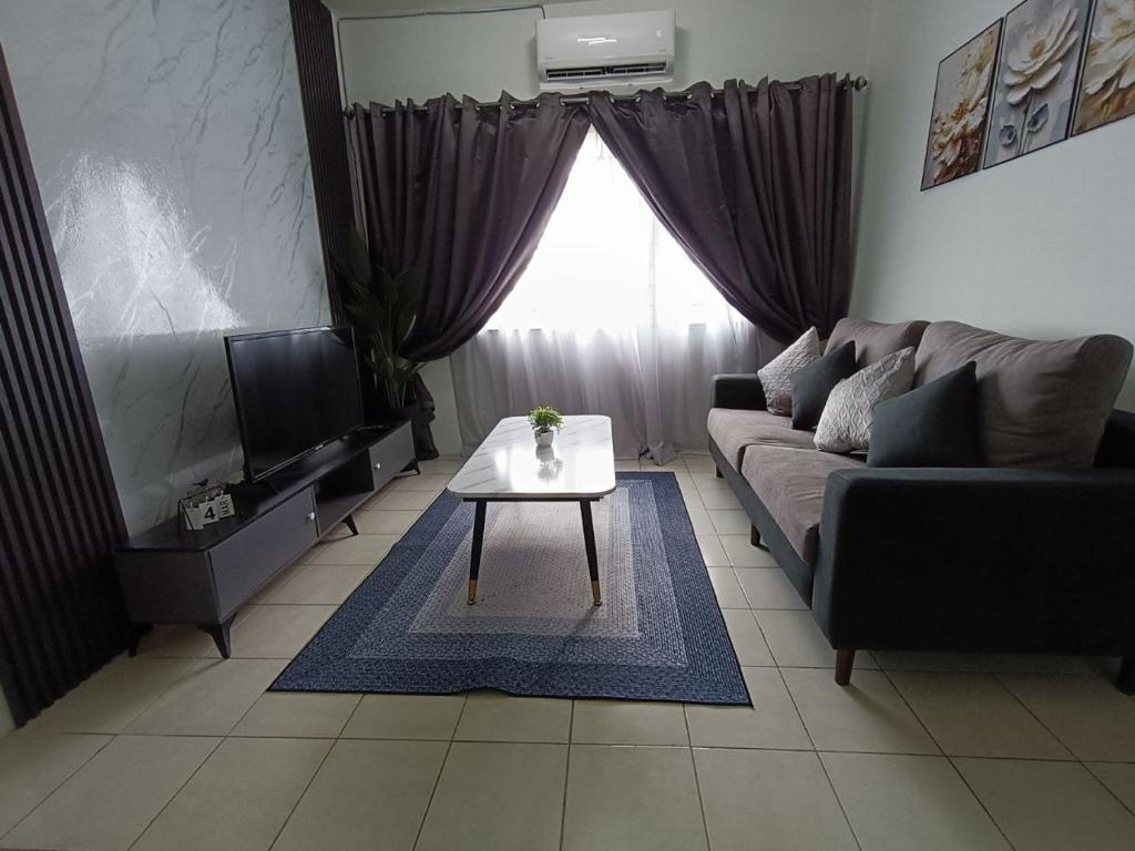 a living room with a couch and a table at Cozy Nest at Coutryhomes Rawang by Bliss Stay Management in Rawang