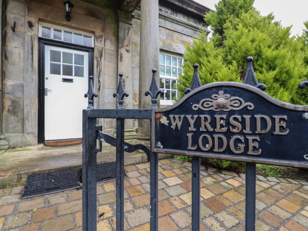 a sign in front of a house with a white door at The Lodge House in Lancaster