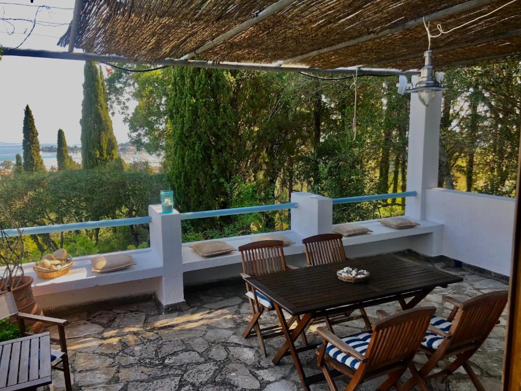 un patio con tavolo, sedie e vista di Sea View Apartment in the Greek Nature a Gouviá