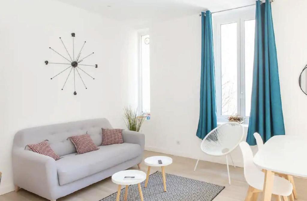 un salon avec un canapé et une horloge au mur dans l'établissement AMAZING LARGE 1-BEDROOM, à Cannes