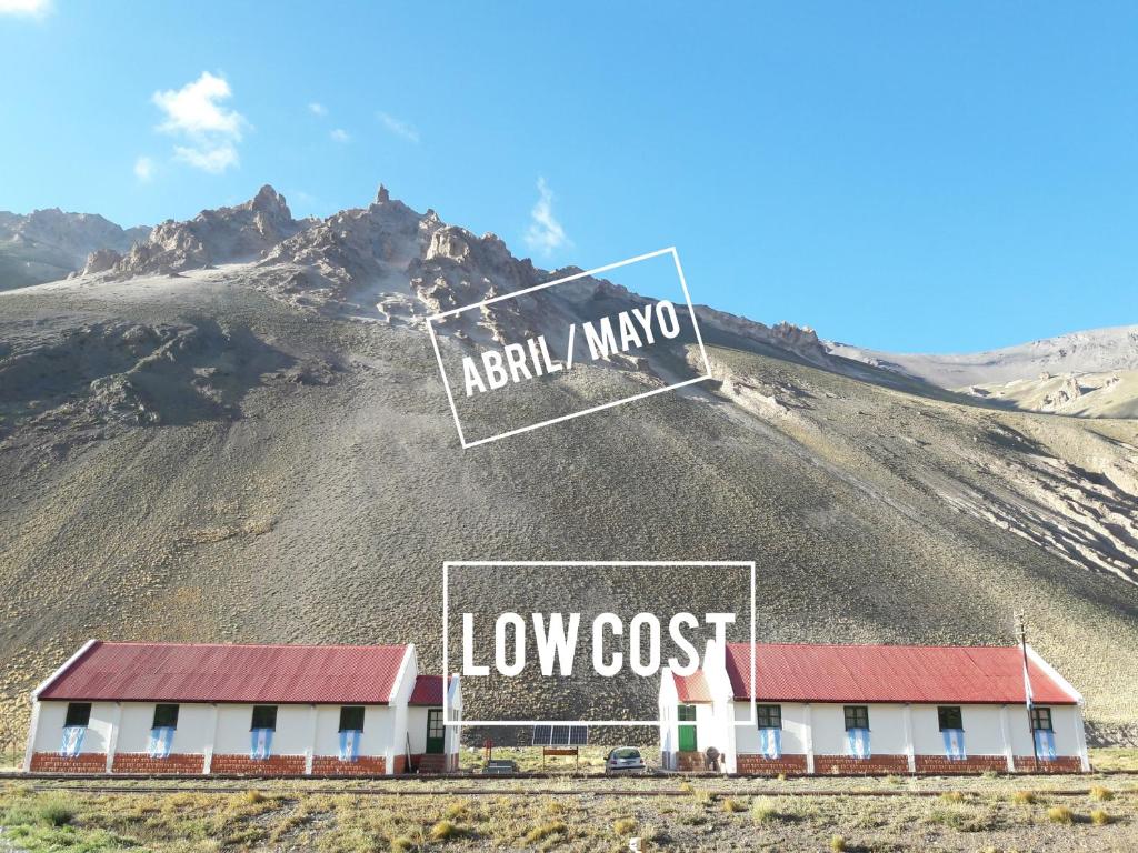 a building on a hill with a sign on it at Hospedaje Leñas del Tolosa in Las Cuevas