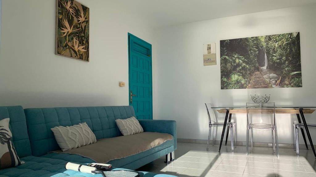 sala de estar con sofá azul y mesa en Appartement Ciel et Mer, en Schœlcher