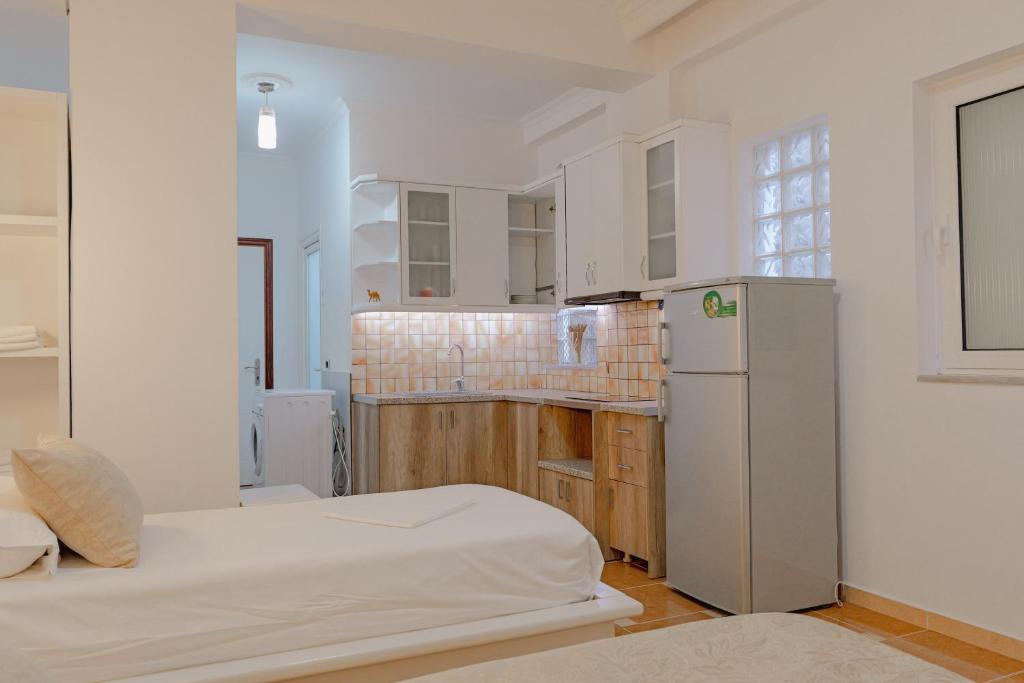 a kitchen with two beds and a refrigerator at Villa Xika in Sarandë