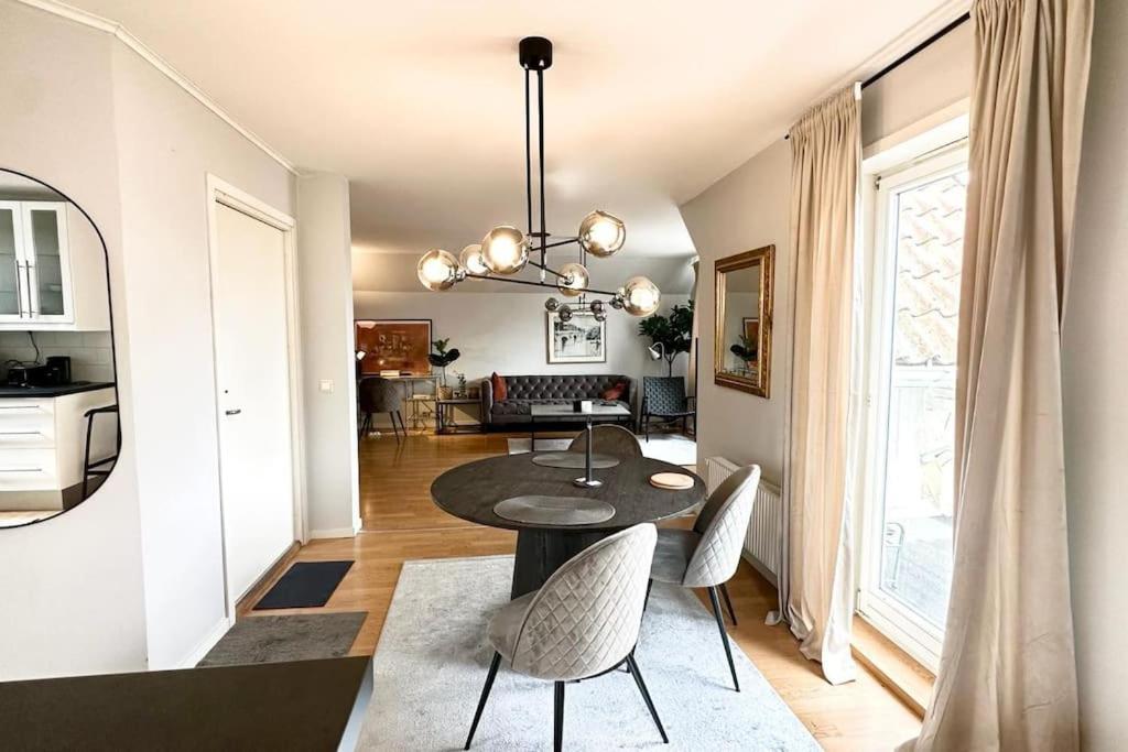 a dining room and living room with a table and chairs at Lyxig våning centralt i Göteborg in Gothenburg