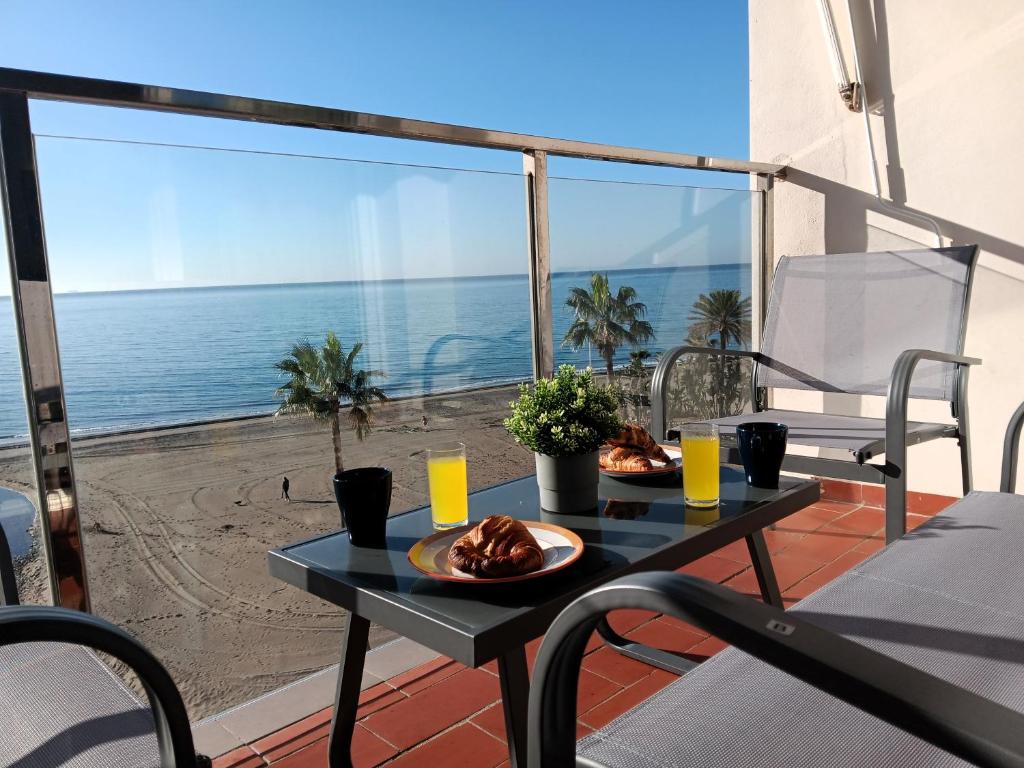 uma mesa numa varanda com vista para o oceano em Alojamiento Iberia Playa em Estepona