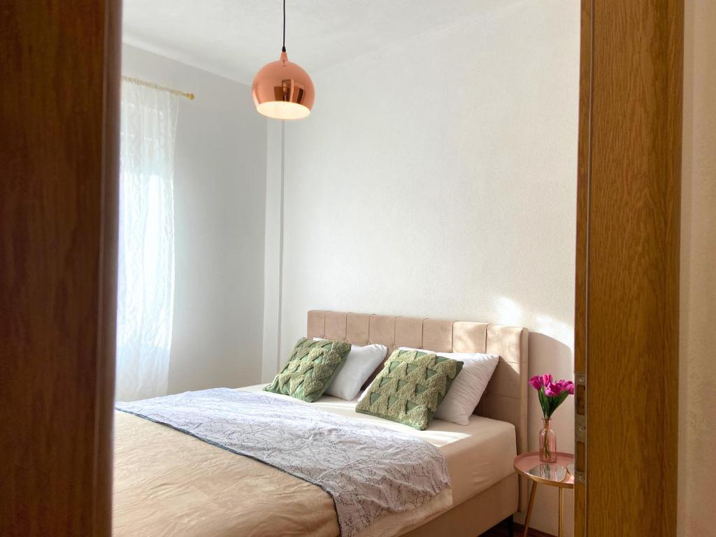 a bedroom with a bed with two green pillows at Boho Apartments in Trebinje