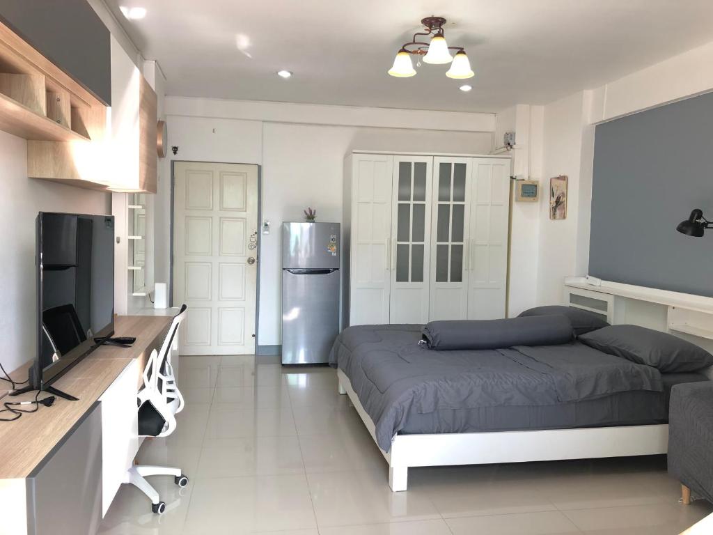 a bedroom with a bed and a refrigerator in it at Cozy Patong studio apartment in Patong Beach