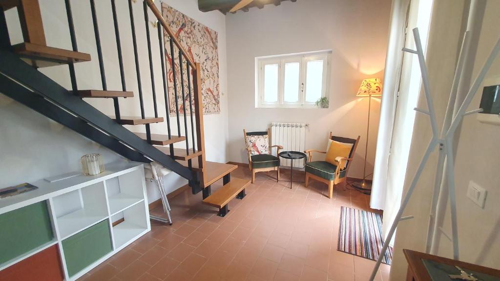 - un salon avec un escalier, une table et des chaises dans l'établissement RomagnaBNB Colonna, à Bertinoro