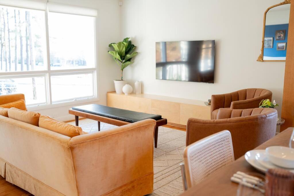 ein Wohnzimmer mit einem Sofa und einem Tisch in der Unterkunft The Mulberry on Bragg in Raleigh