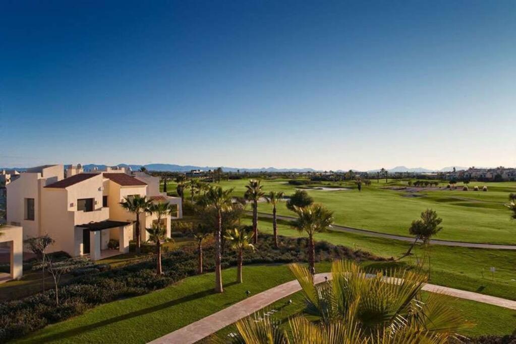 an aerial view of a golf course with palm trees at Roda Golf. Poolside apartment in Murcia