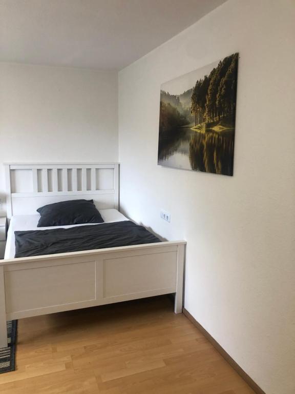 ein Schlafzimmer mit einem Bett und einem Wandgemälde in der Unterkunft Apartment 6 am Stuttgarter Flughafen-Messe in Leinfelden-Echterdingen