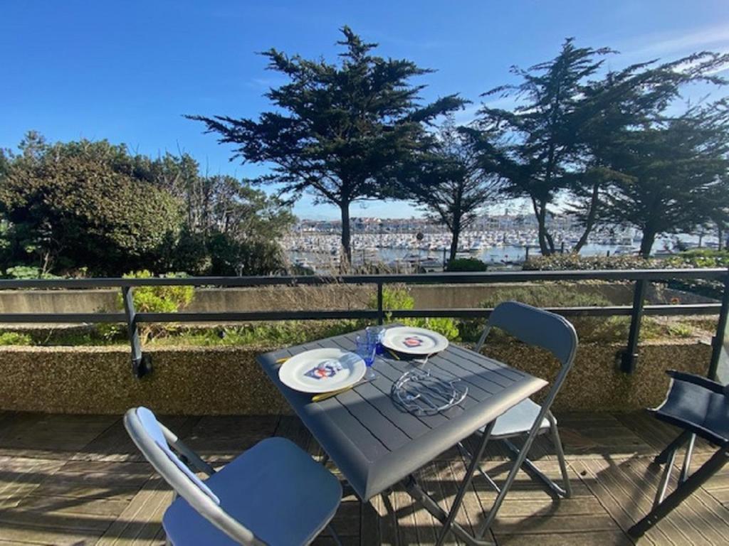 - une table et des chaises sur une terrasse avec vue sur la ville dans l'établissement Le New Port, à Saint-Gilles-Croix-de-Vie