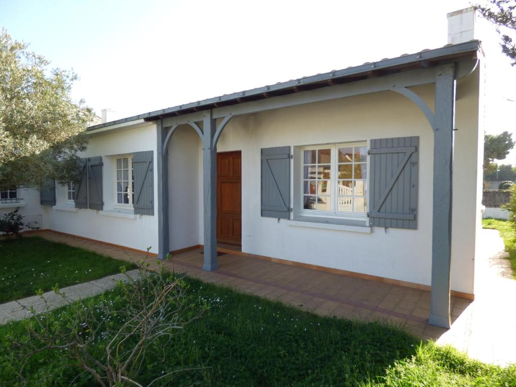 une petite maison blanche avec une porte rouge dans l'établissement Les Rochers, à Saint-Gilles-Croix-de-Vie