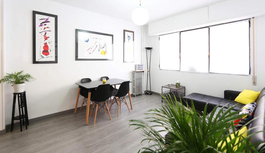 ein Wohnzimmer mit einem Tisch und einem Sofa in der Unterkunft CasaGoa in Madrid