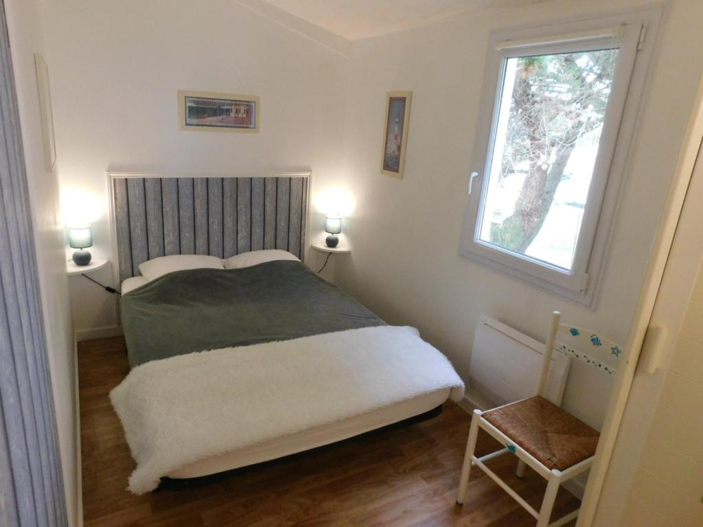 Habitación pequeña con cama y ventana en La Villa Bleue avec piscine, en Bretignolles-sur-Mer