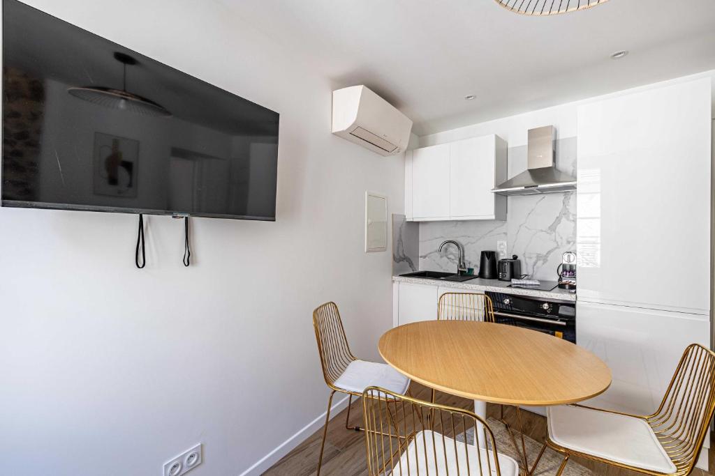 a small kitchen with a wooden table and chairs at Cozy renovated 1 bedroom Suquet Cannes Center - 1BR in Cannes
