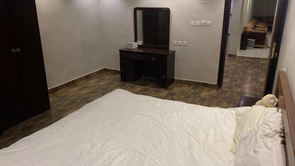 1 dormitorio con cama, tocador y espejo en إستراحة المزرعة en Abha