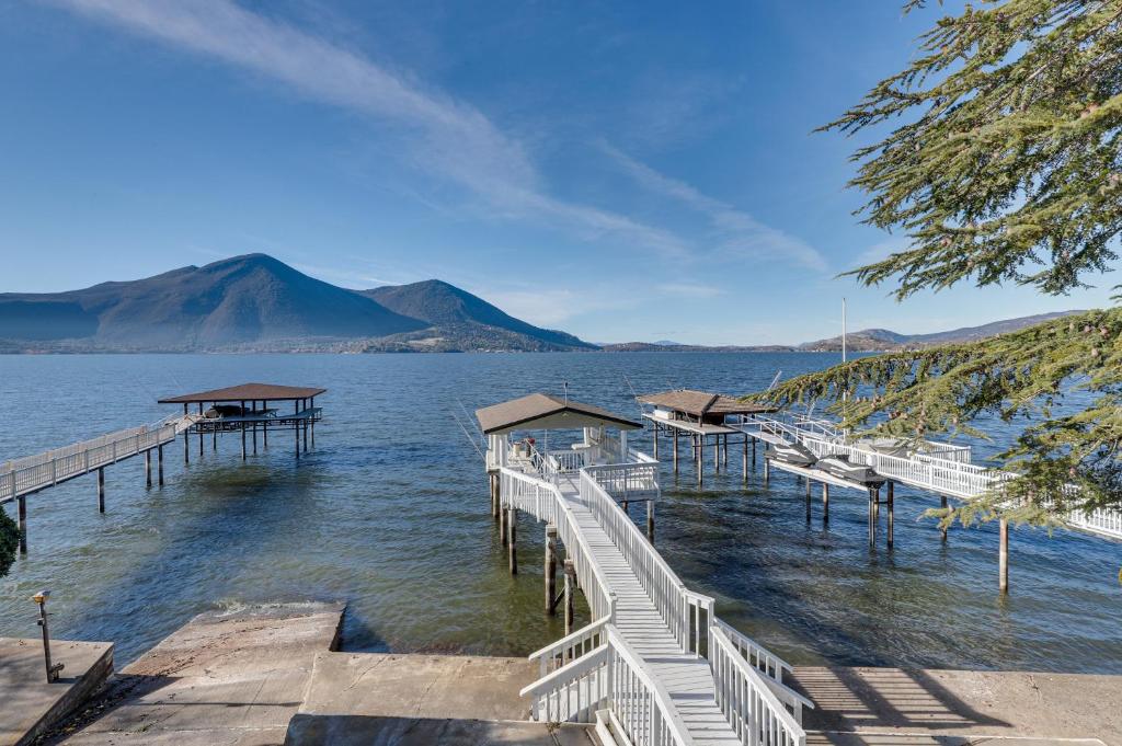 a dock on a lake with a mountain in the background at Lakefront California Escape with Deck and Boat Dock! in Clearlake