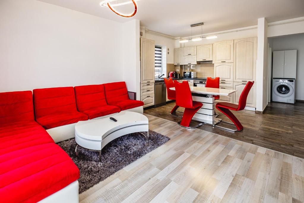 un soggiorno con divano rosso e sedie rosse di Leon's home a Şelimbăr