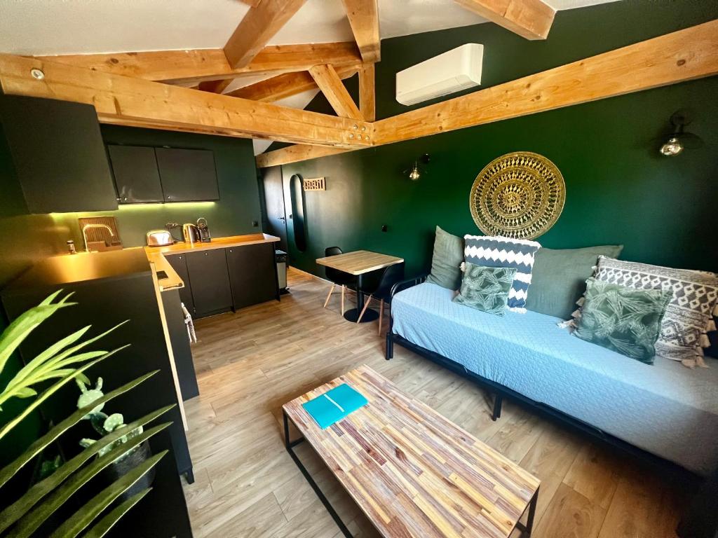 Una sala de estar con un sofá azul y una mesa. en Le Clocher de Cassis, en Cassis