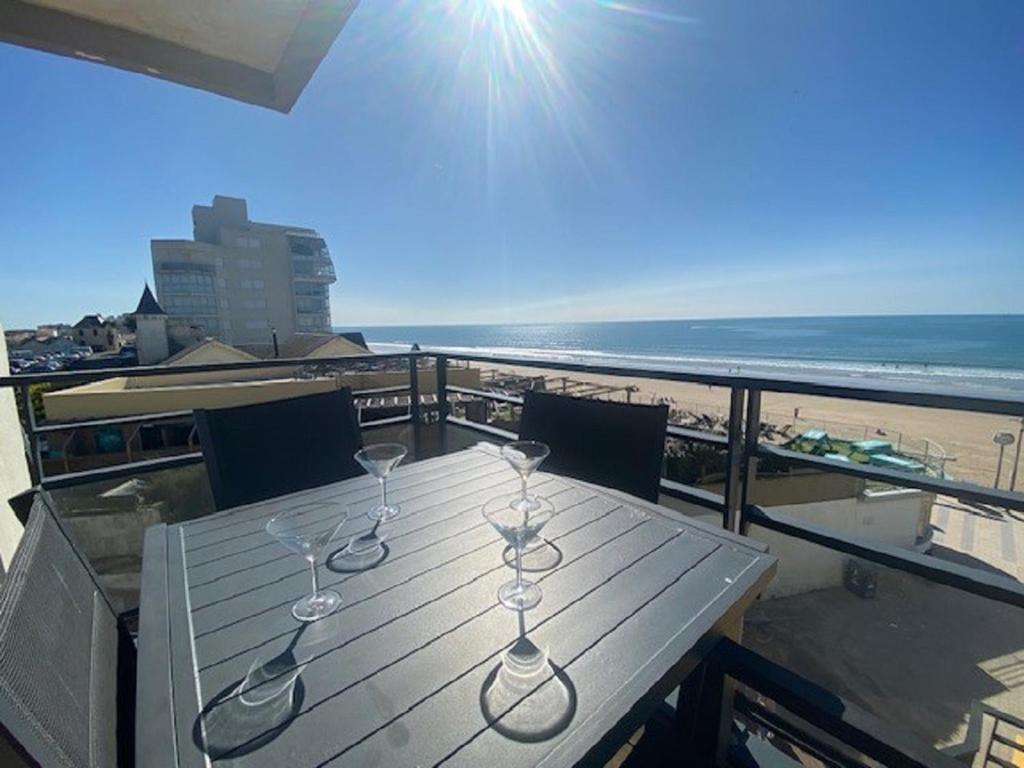 - une table avec des verres à vin sur un balcon donnant sur la plage dans l'établissement Le Banc de Sable, à Saint-Gilles-Croix-de-Vie