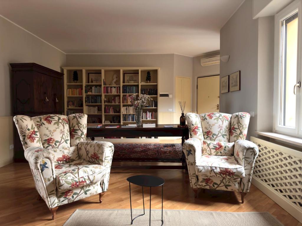 a living room with two chairs and a piano at Chez Papa Appartamenti - Chez Coco in Ravenna