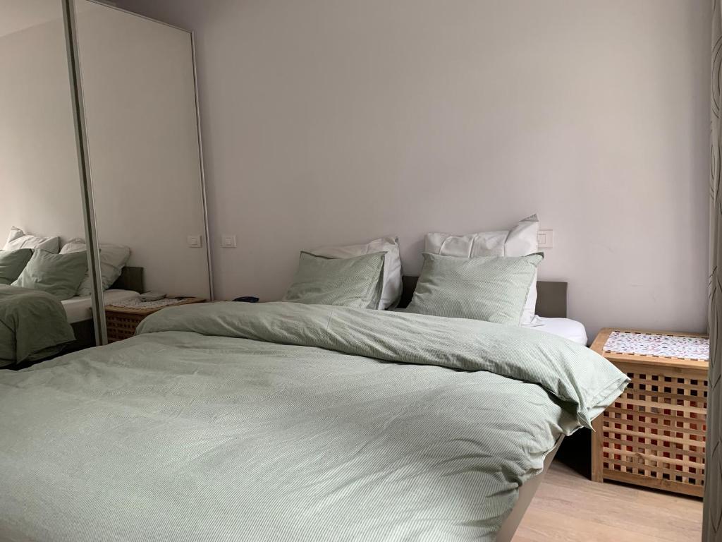 1 dormitorio con 1 cama grande y espejo en Residentie beethoven en Knokke-Heist