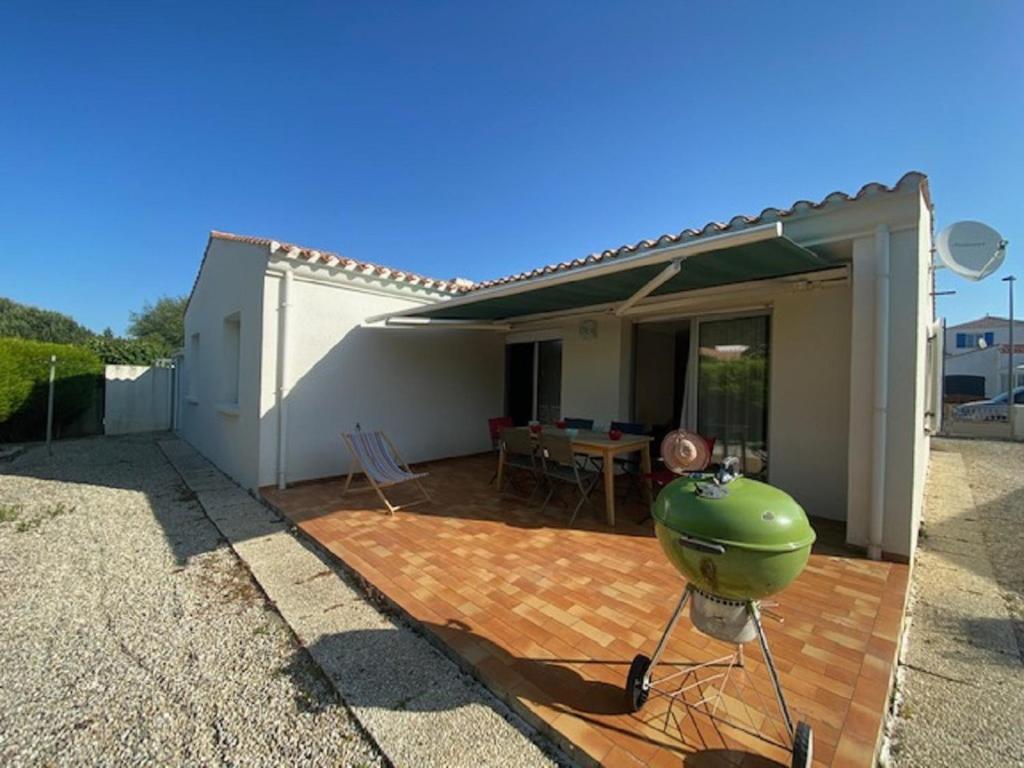 a patio with a grill and a table in front of a house at Maison au calme et a 2 pas de la plage in Saint-Gilles-Croix-de-Vie