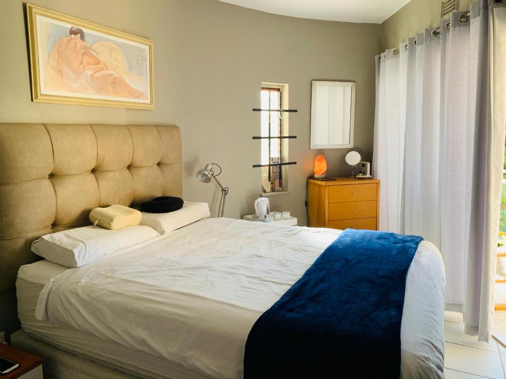 a bedroom with a large bed with a blue blanket at Beachfront apartment in Ballito! Casablanca in Ballito