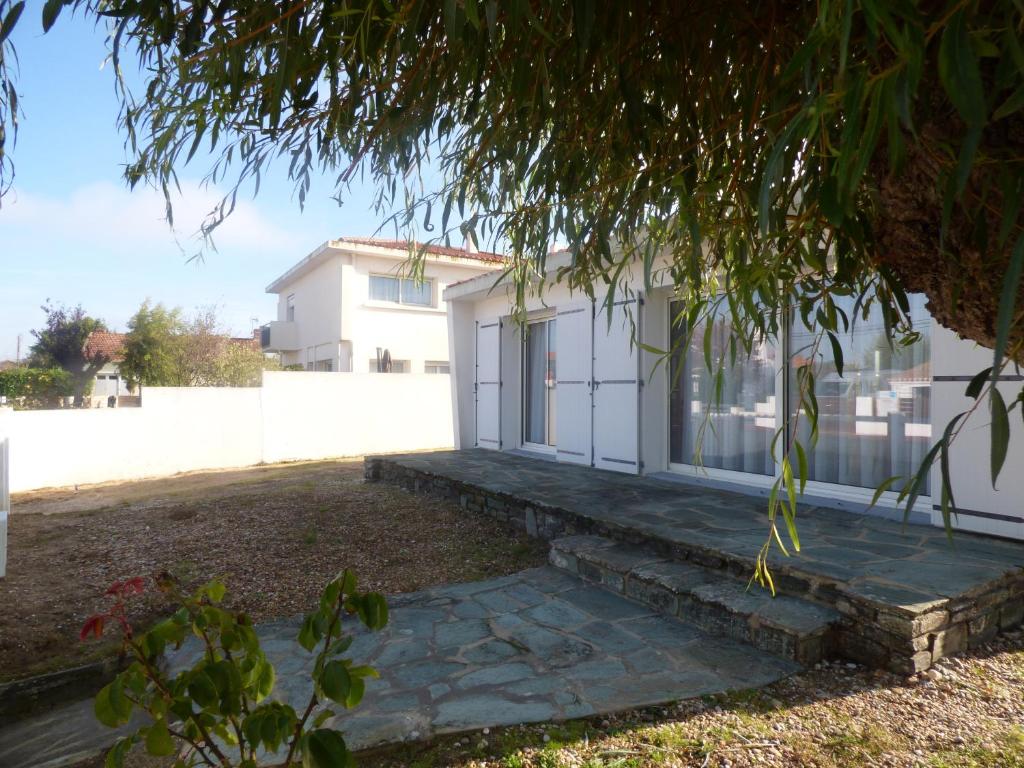 une maison blanche avec une passerelle en pierre devant dans l'établissement La Sauvageonne, à Saint-Gilles-Croix-de-Vie