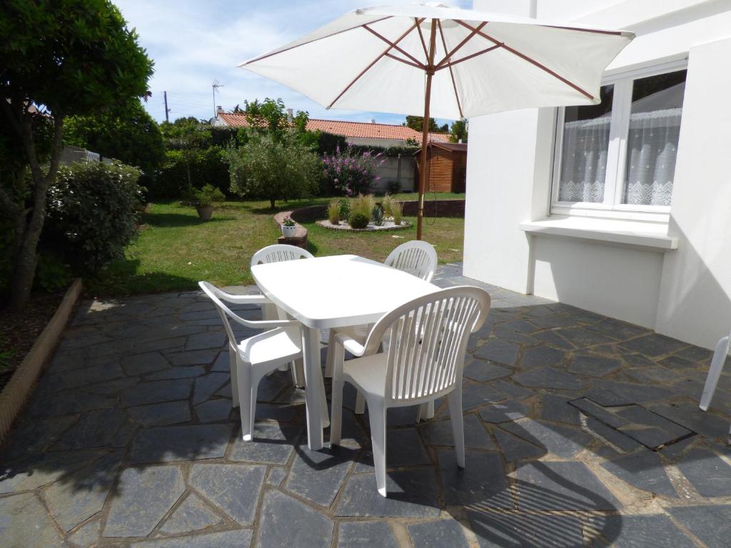 une table et des chaises avec un parasol sur une terrasse dans l'établissement L'Atlantique, à Saint-Gilles-Croix-de-Vie