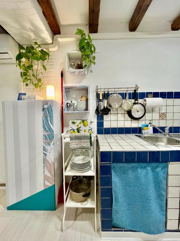 małą kuchnię z niebieskimi i białymi płytkami w obiekcie Casa Myrtos w mieście Palermo