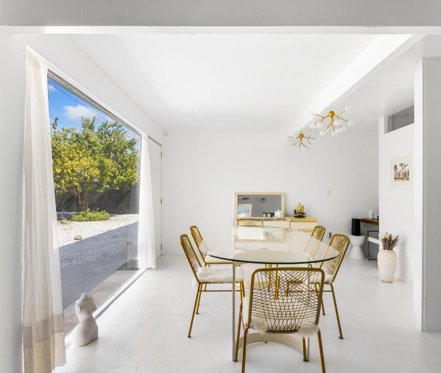 ein weißes Esszimmer mit einem Tisch und Stühlen in der Unterkunft Former Steve McQueen’s home in Palm Springs