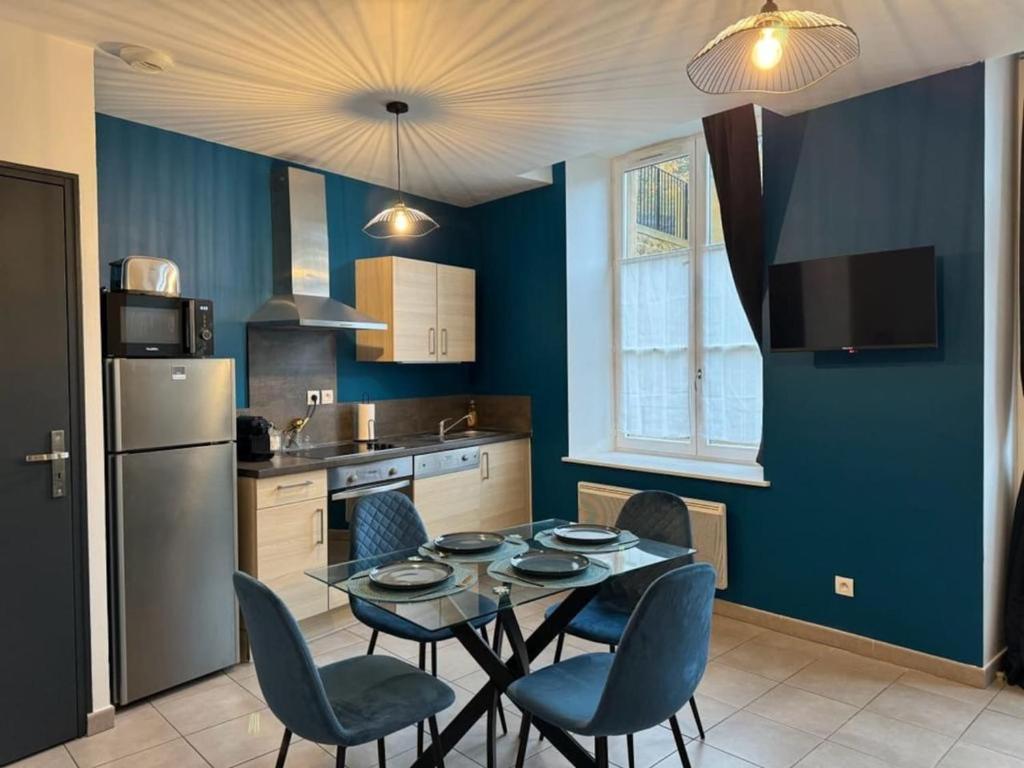 eine Küche mit einem Tisch und Stühlen sowie einem Kühlschrank in der Unterkunft Appartement d'une chambre avec terrasse et wifi a Sedan in Sedan