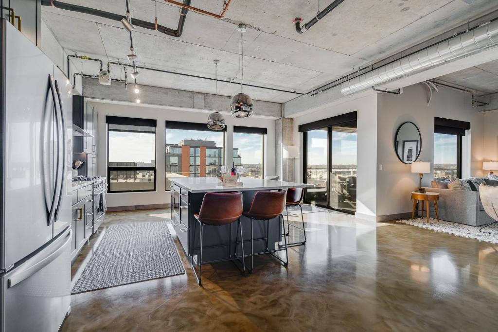 an open kitchen and living room with high ceilings and windows at Sable 71 - loft in Minneapolis