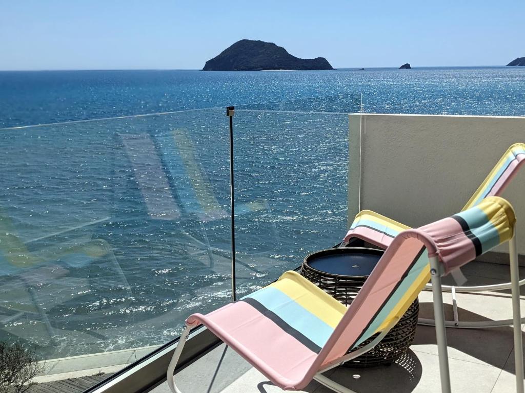 une paire de chaises assises sur un balcon donnant sur l'océan dans l'établissement Panorama Inn, à Lithakia