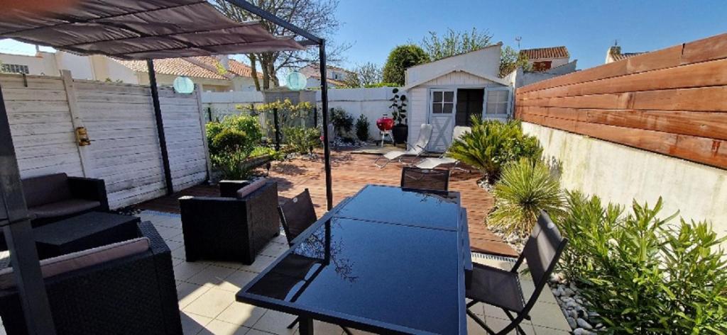 une terrasse avec une table bleue, des chaises et une clôture dans l'établissement La Balise, à Saint-Gilles-Croix-de-Vie