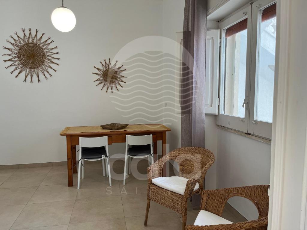 a dining room with a wooden table and chairs at Casa Mireya - Spiaggia a 50m - by Cala Salento in Porto Cesareo