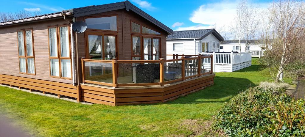 a house with a large deck on the grass at Bluebell Luxury 2 Bedroom Lodge at Southview Holiday Park in Skegness