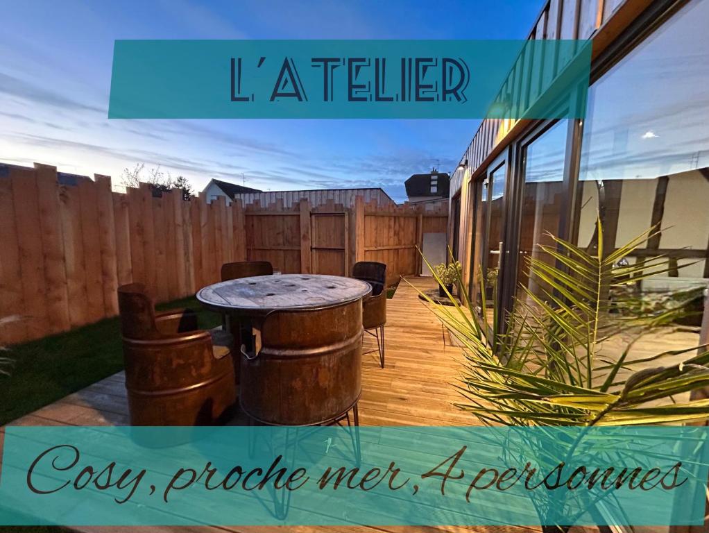 a patio with a table and a fence at L'atelier de la clef des Paons in Luc-sur-Mer