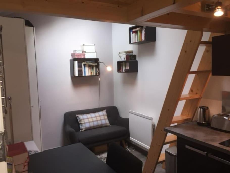 ein Wohnzimmer mit einem Hochbett und einem Stuhl in der Unterkunft Tiny house avec terrasse in Versailles
