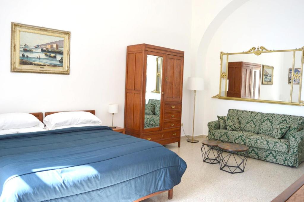 a bedroom with a bed and a couch and a mirror at Plaza Apartment in Salerno