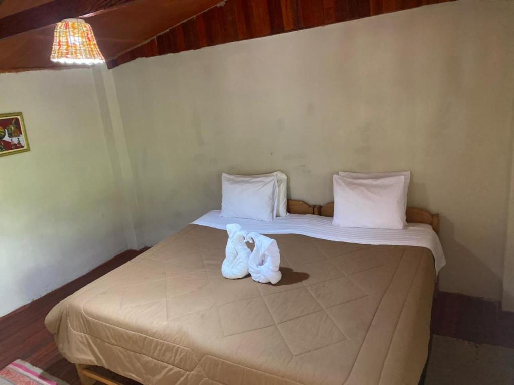 Un dormitorio con una cama con una toalla. en Refugio de Mery Lucmabamba, en Sahuayacu